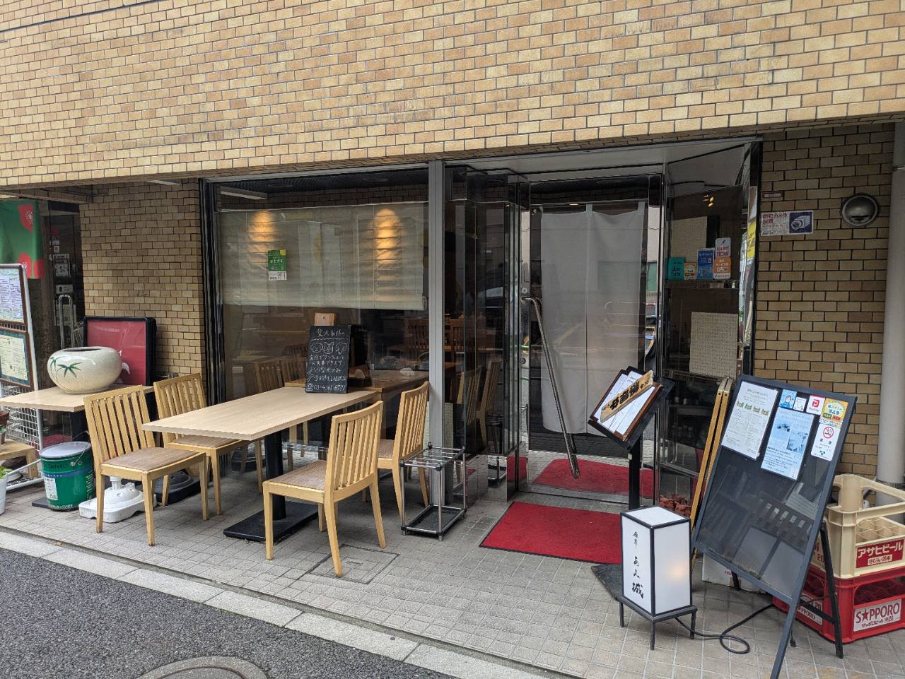 麻布あみ城の外観。テラス席と白い暖簾が目印の麻布十番の和食店