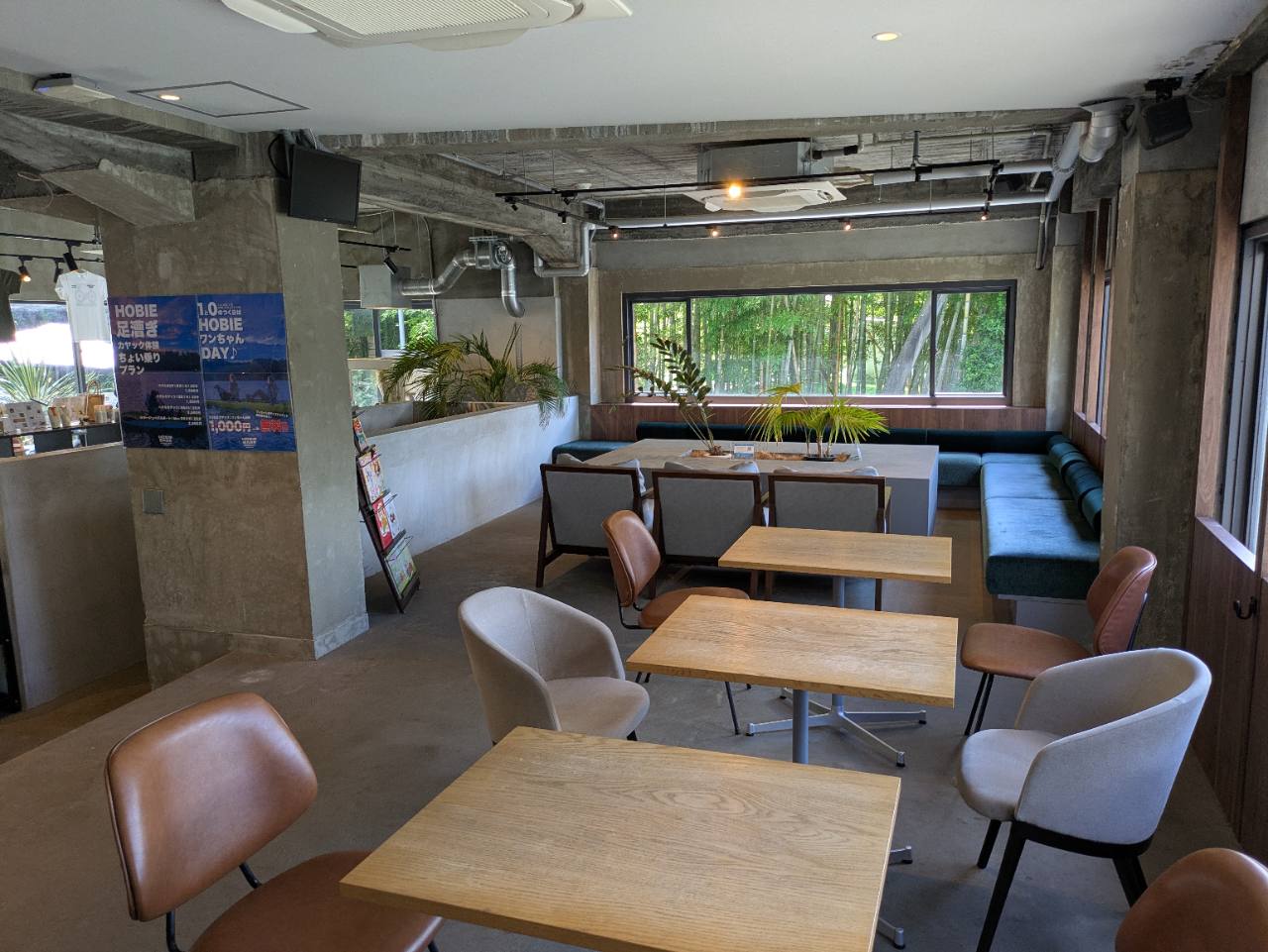 Mahana feat.木梨サイクルの広い店内飲食スペースと窓の外に見える竹林